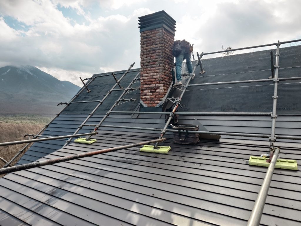 業者が、ログハウスのメンテナンスをしている写真